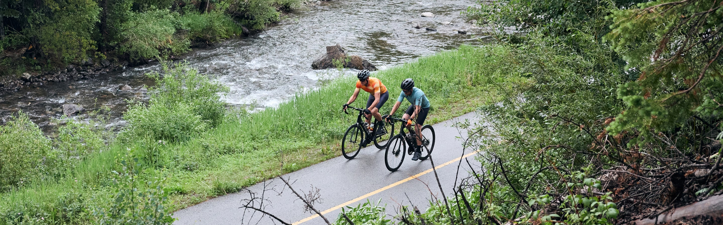 Cyclist Riding Bicycles on Bike Path Next to River